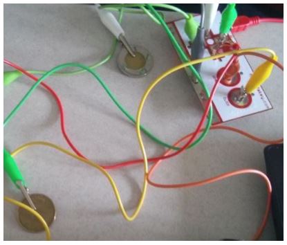An image of the coins being hooked up through the Makey Makey interface.